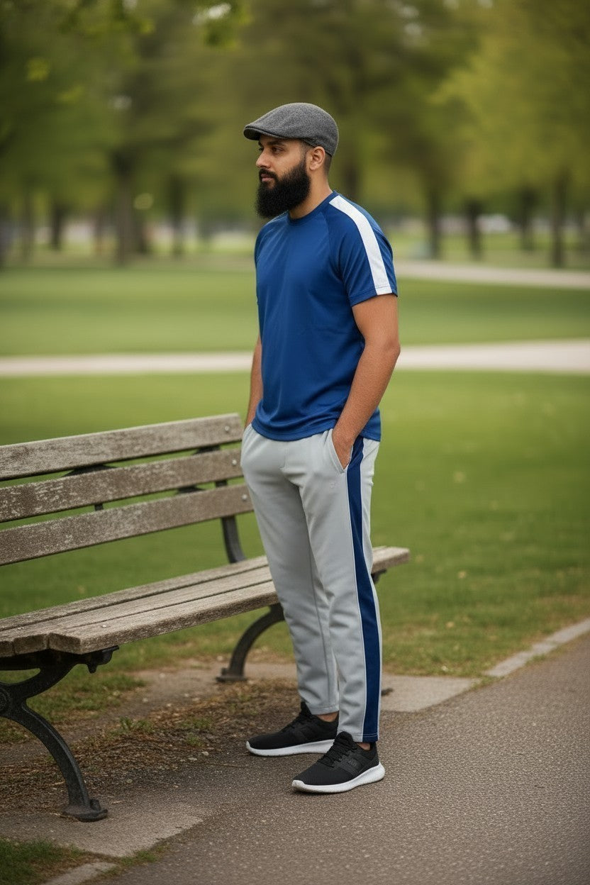 Sunnah Conscious navy blue and steel grey tracksuit with white side stripes worn by a man in a park setting