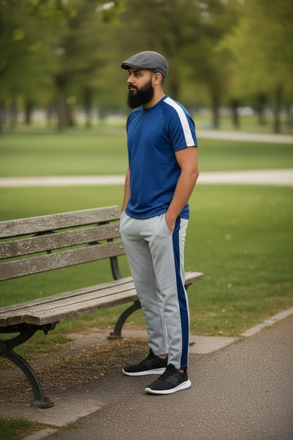 Sunnah Conscious navy blue and steel grey tracksuit with white side stripes worn by a man in a park setting